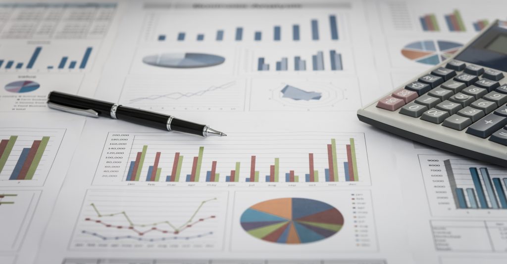 financial graph and chart report with pen, calculator on desk of financial advisor.